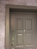 Доборы и наличники входной двери в квартиру с выкрасом под заказ фото крупным планом